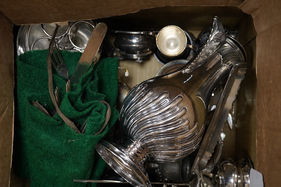 A quantity of assorted plated wares including a hot water jug, an egg coddler, salts, an entrée dish and cover, a crumb scoop, a horn handled fork, knife rests, trophy cups, a cream jug, a tea pot stand, together with tw